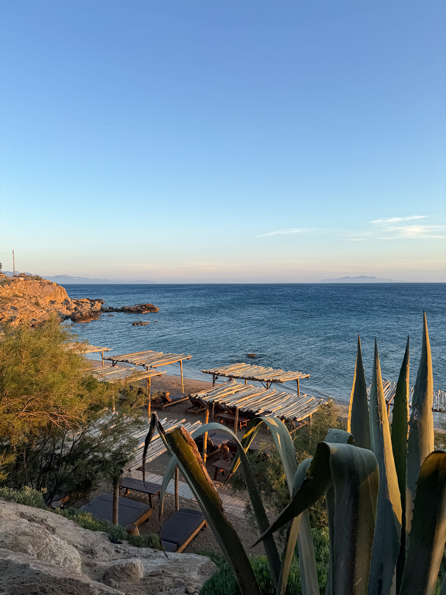 Golden hour view over a quiet beach club and calm blue sea