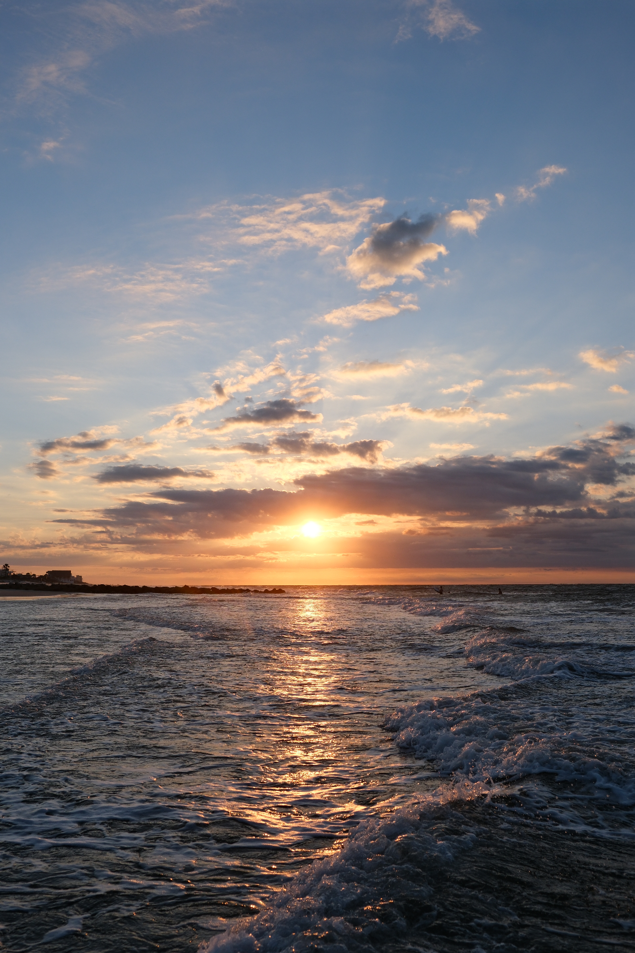 Sunrise over the Atlantic with surfers in the distance at Folly Beach