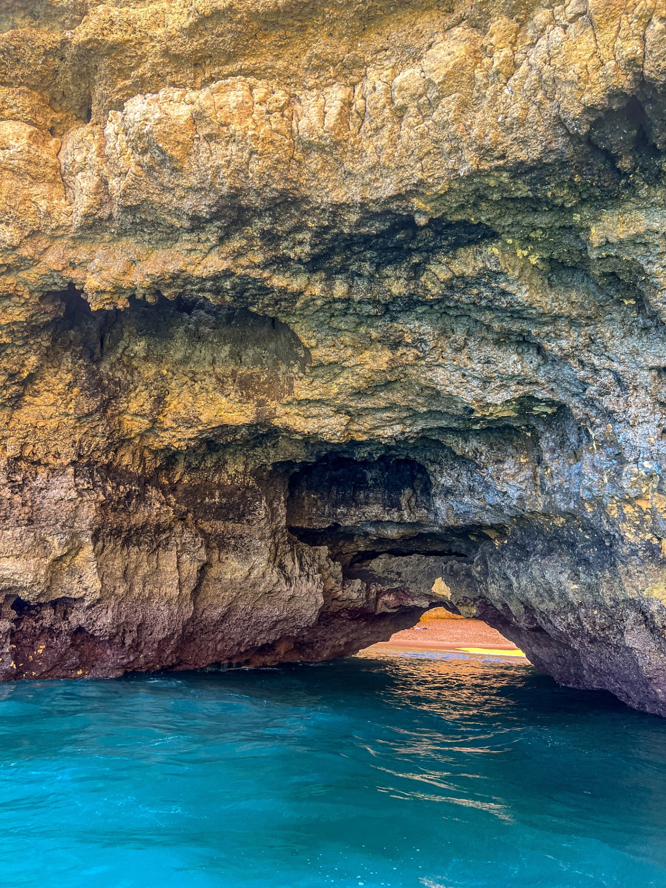Close view inside a limestone sea cave with bright turquoise water
