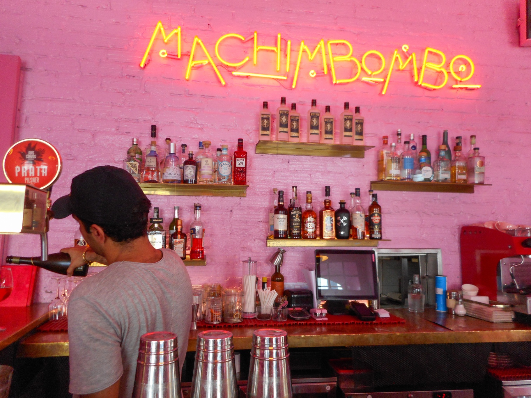 Bartender pouring at Machimbombo, a pink neon-lit bar in Lisbon