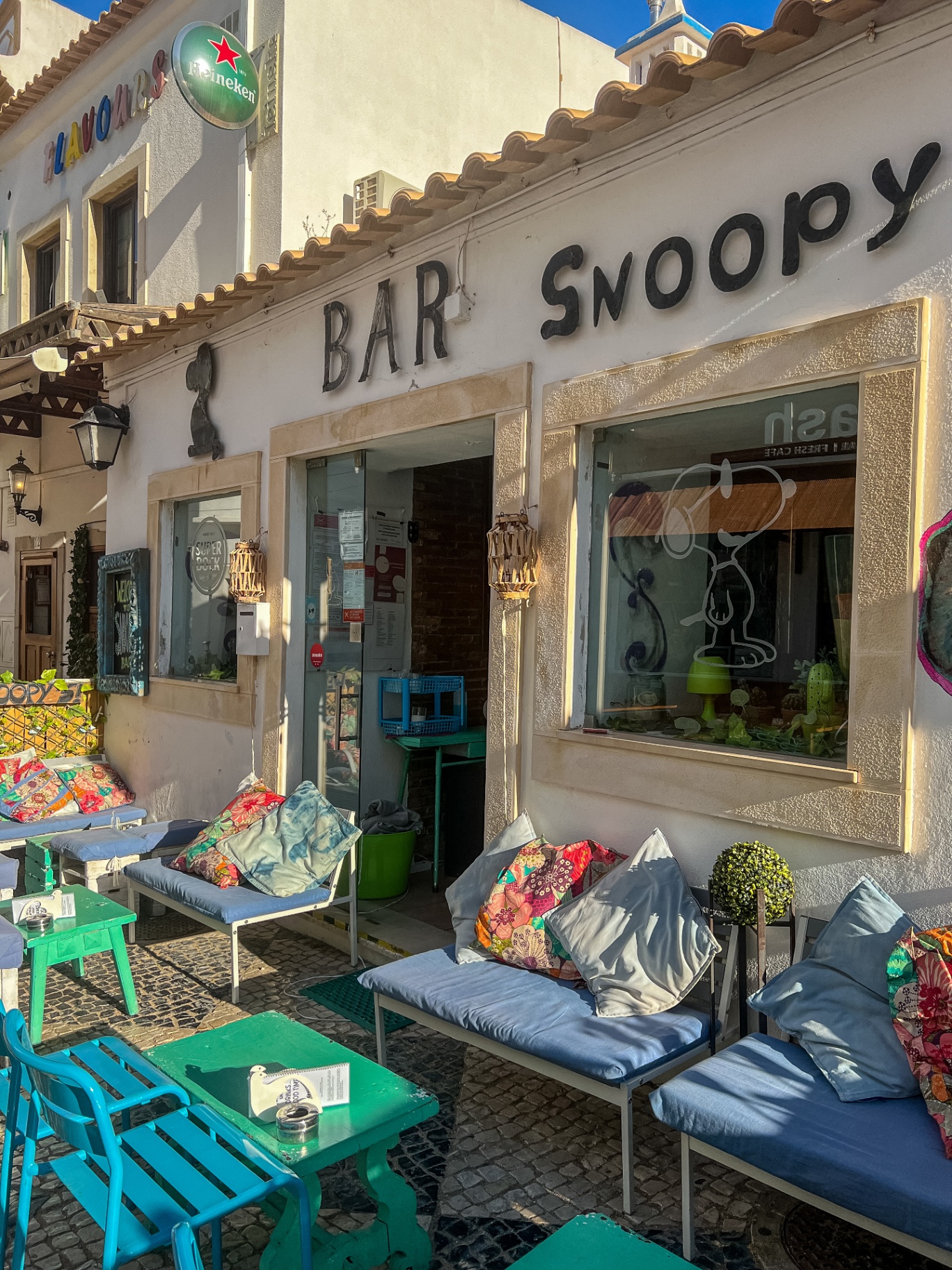 Bar Snoopy storefront in the Algarve with colorful cushions and tiled patio