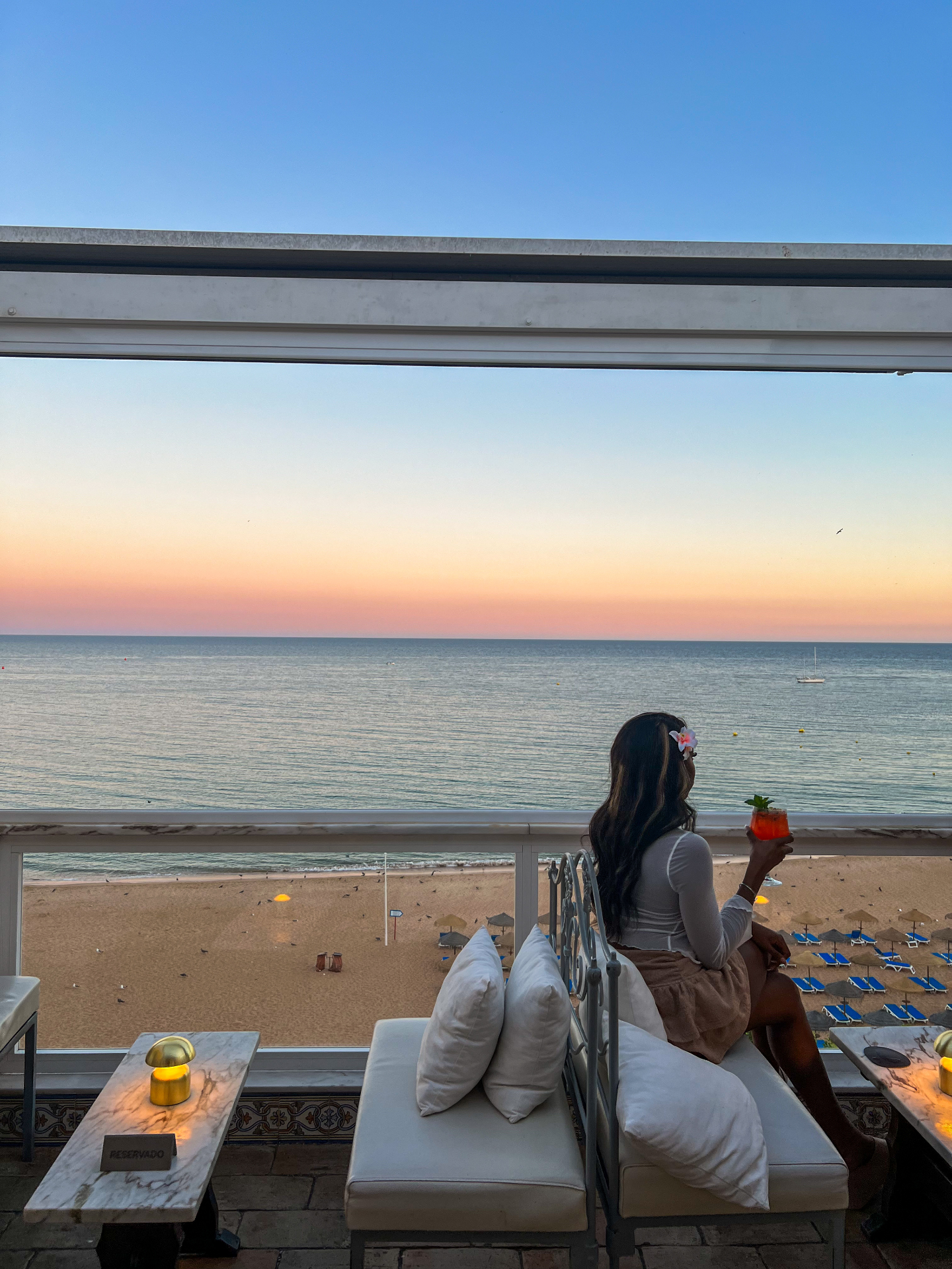 Watching the Algarve sunset from a beachfront balcony with a cocktail in hand