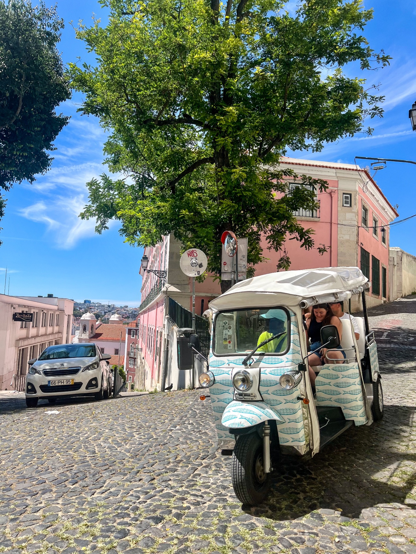 Tuk tuk on a cobblestone hill in Alfama, Lisbon